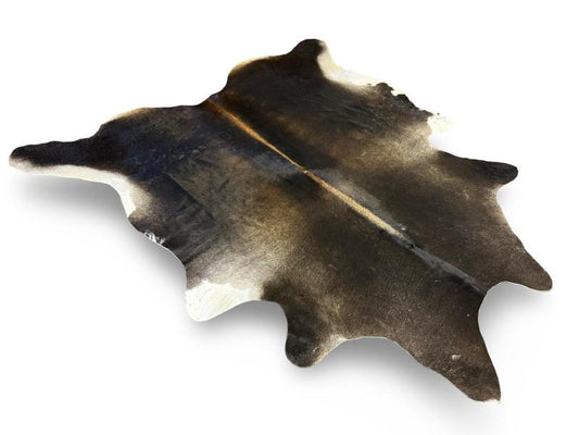 Tri color cowhide,a mix of black and light brown with a light brown spine and white under legs